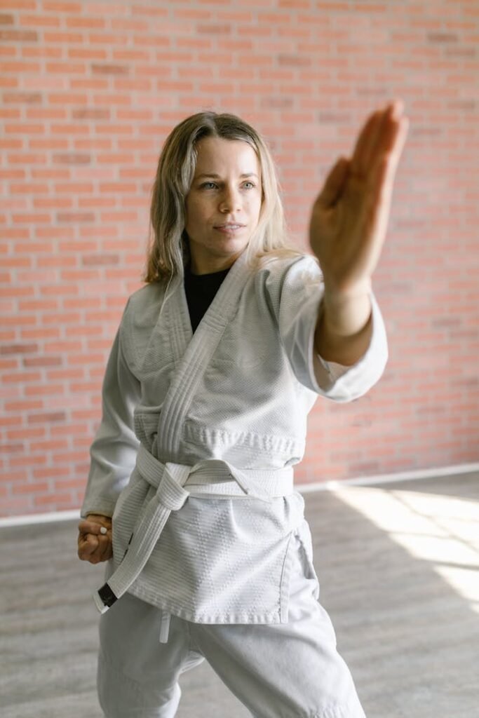 A Woman in White Uniform while Doing Karate Position